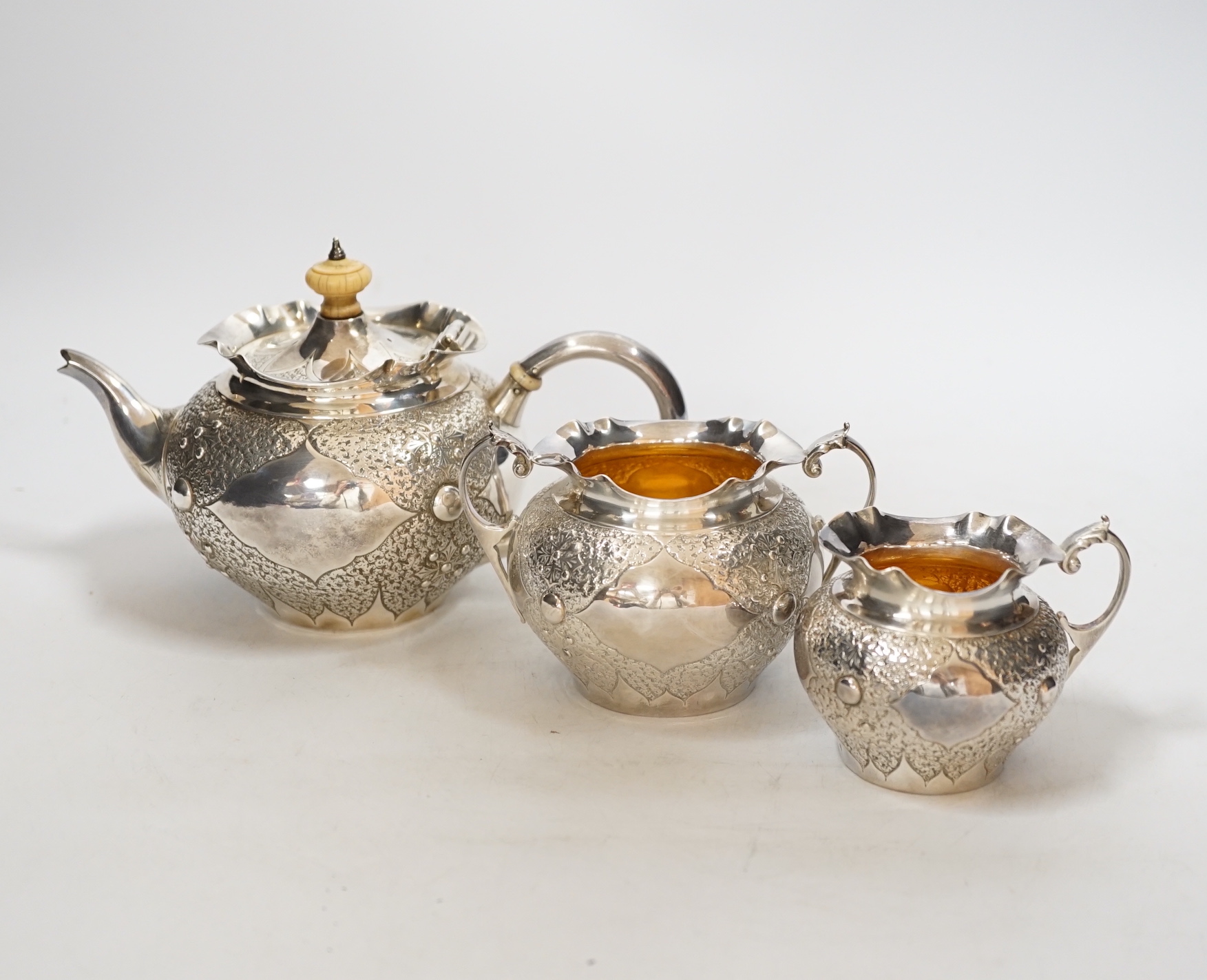 A Victorian embossed silver three piece bachelors tea set, Charles Edwards, London, 1880, gross weight 17.9oz., CITES Submission reference WAD4FJG4